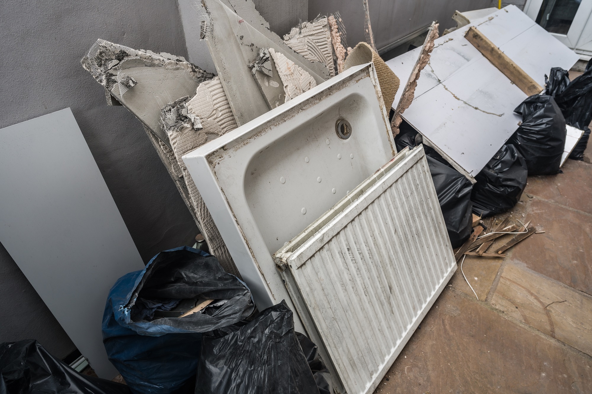 Shower,Base,And,White,Metal,Radiator,Against,Garbage,Heap,,Waste